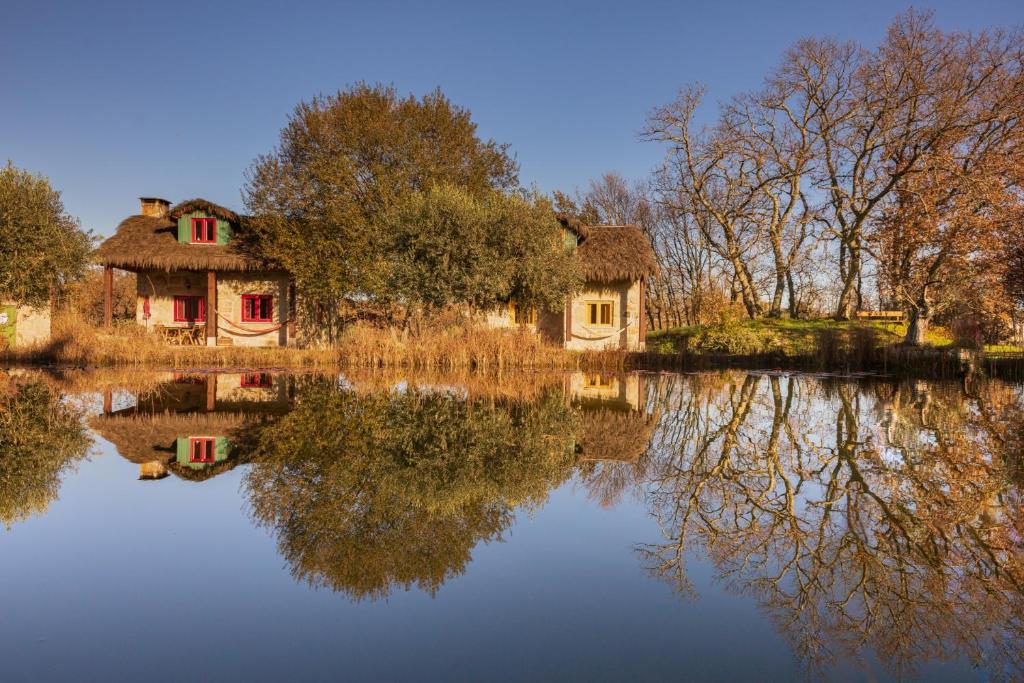 un reflet de deux maisons dans l'eau dans l'établissement Chão do Rio - Turismo de Aldeia, à Seia