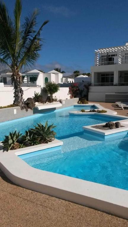 a swimming pool with blue water in a resort at Apartamento Lory-Puerto del Carmen in Tías
