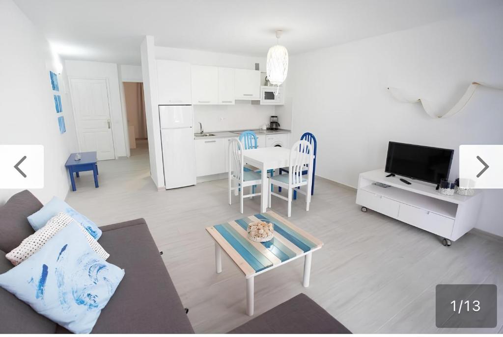 a living room with a couch and a table and a kitchen at Apartamento SARA en el complejo Teguisol in Costa Teguise