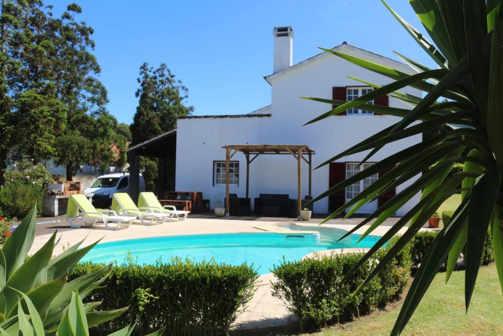 a swimming pool in front of a white house at Batalha House in Ponta Delgada
