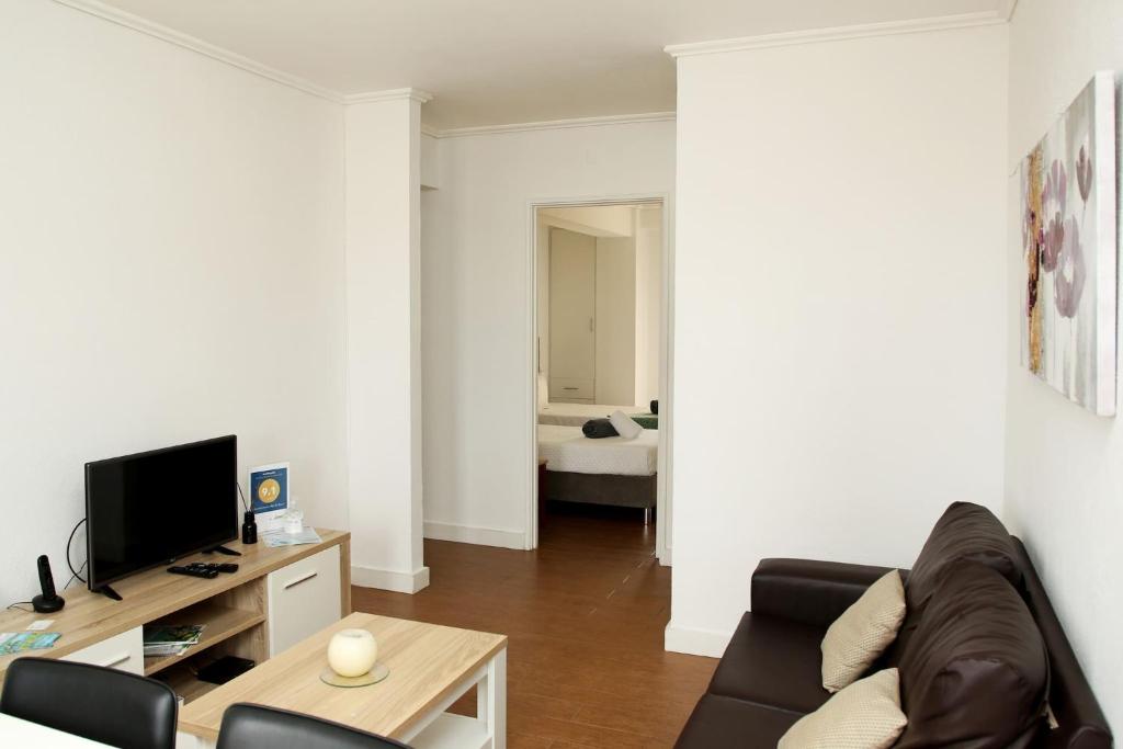 uma sala de estar com um sofá e uma televisão em Apartamento Mãe de Deus em Ponta Delgada