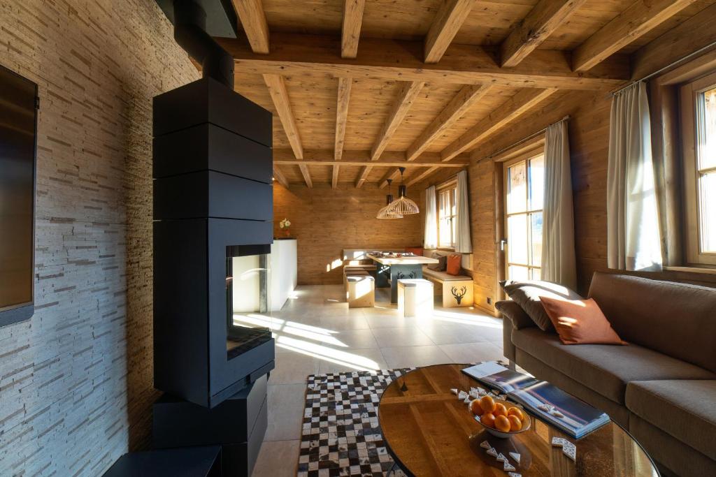 a living room with a couch and a fireplace at Chalet Chäserrugg - Luxury, Sauna, Whirlpool & Mountain View in Wildhaus