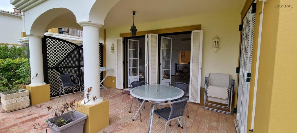 een kamer met een tafel en stoelen op een patio bij Pestana Golf Resort - T2 71d in Carvoeiro