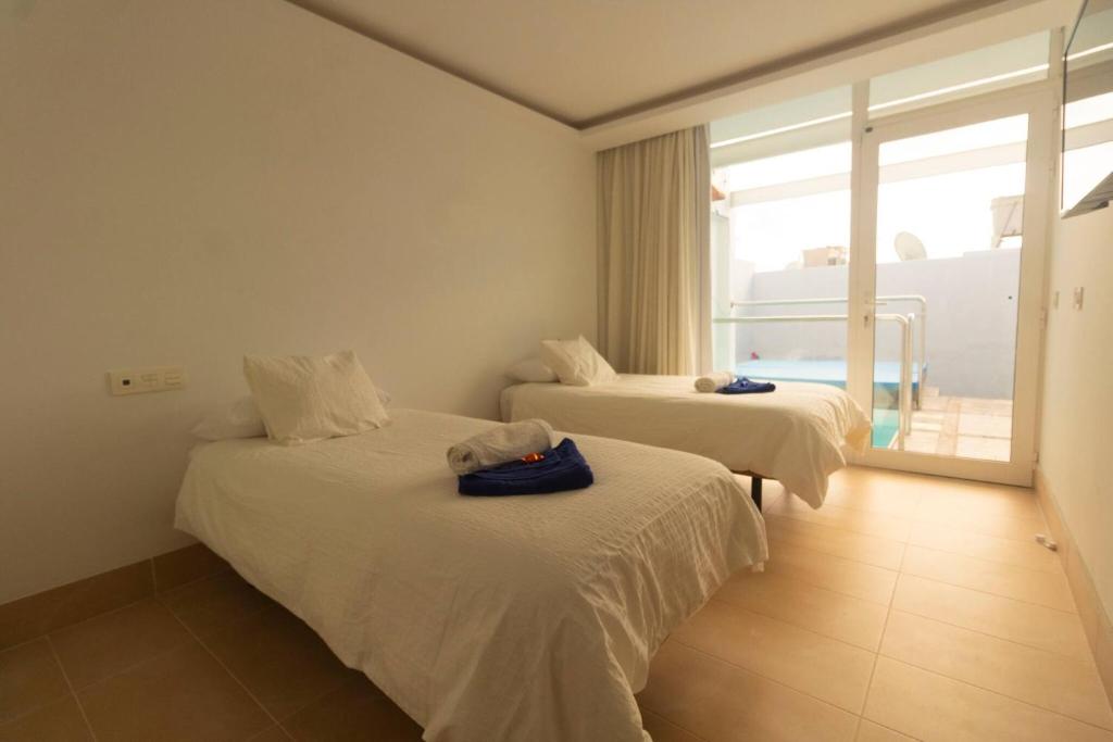 two beds in a room with a view of the ocean at Luxury Villa Rincon del Mar- Old Town - Puerto del Carmen in Puerto del Carmen