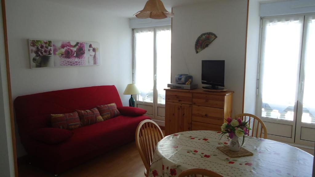 un salon avec un canapé rouge et une table dans l'établissement T2 Luchon Centre 5 nuits minimum, à Luchon