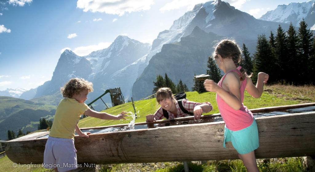 two children playing in a hot tub in the mountains at Camping Jungfrau in Lauterbrunnen