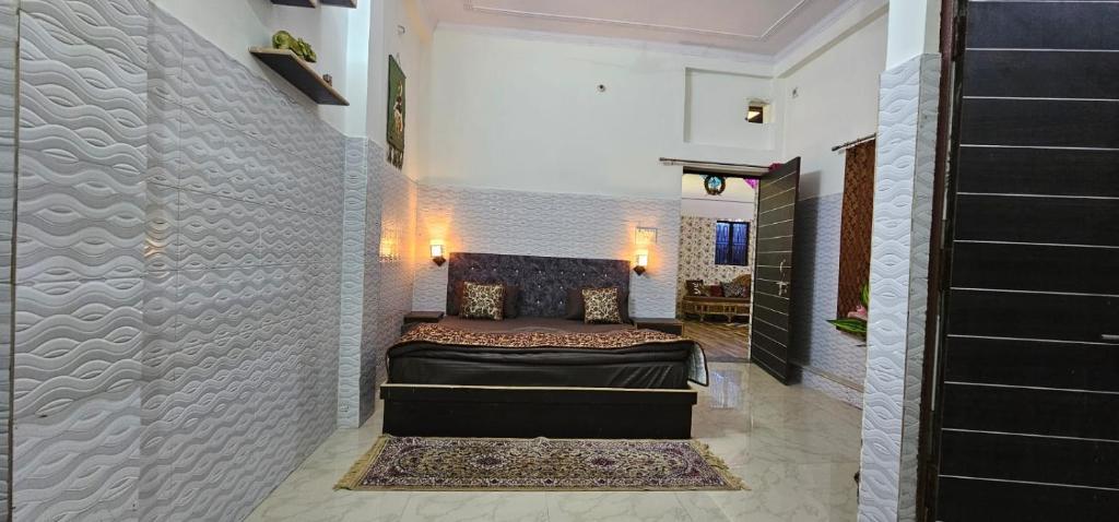 1 dormitorio con cama y pared en Mayur Villa, en Agra