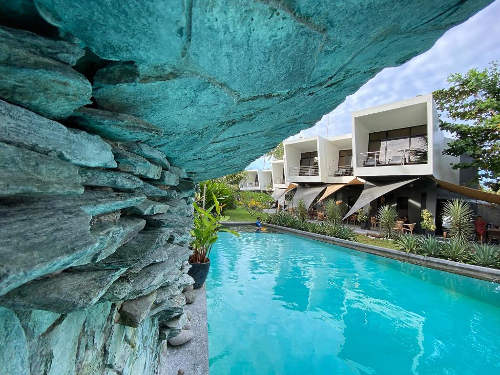 a resort with a rock wall next to a swimming pool at Mahi Mahi Dive Resort in Zamboanguita