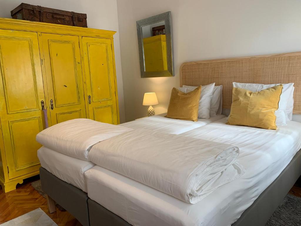 a bedroom with a large white bed with yellow cabinets at Beautiful Private Room next to Lisbon - NEW in Paço de Arcos