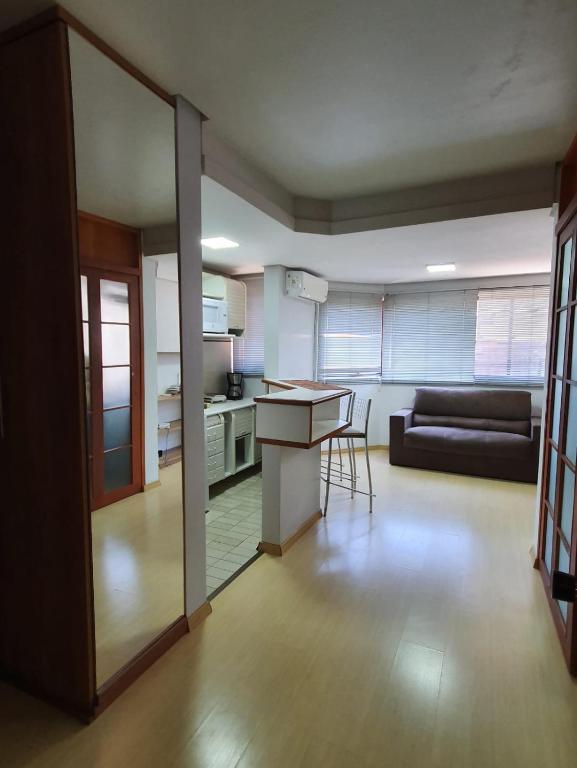 a kitchen and living room with a couch and a table at Flat Wall Street in Caxias do Sul