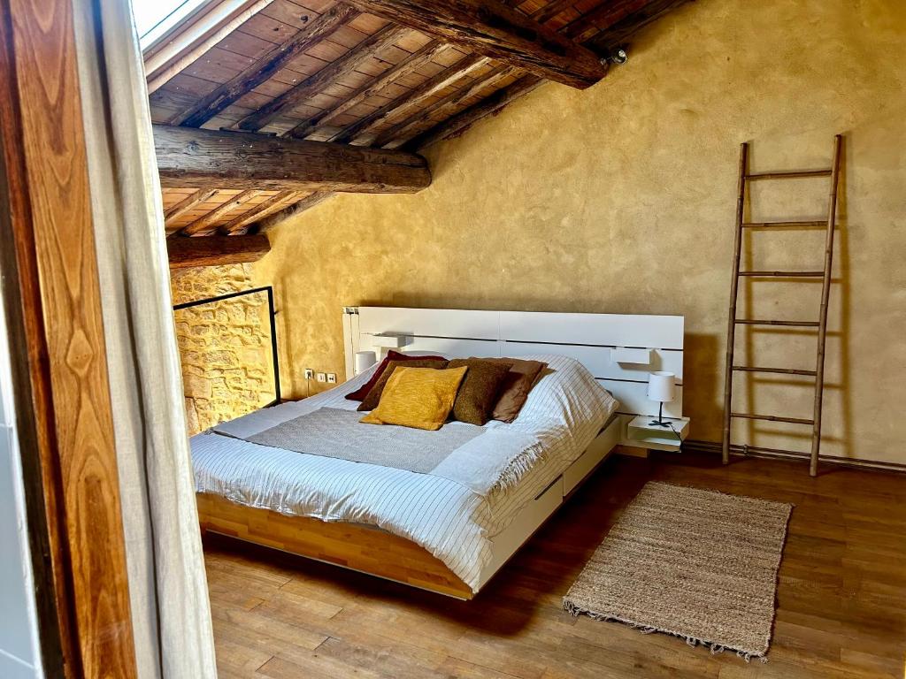 um quarto com uma cama com almofadas amarelas e uma escada em Crocoloft Nimes Centre em Nîmes