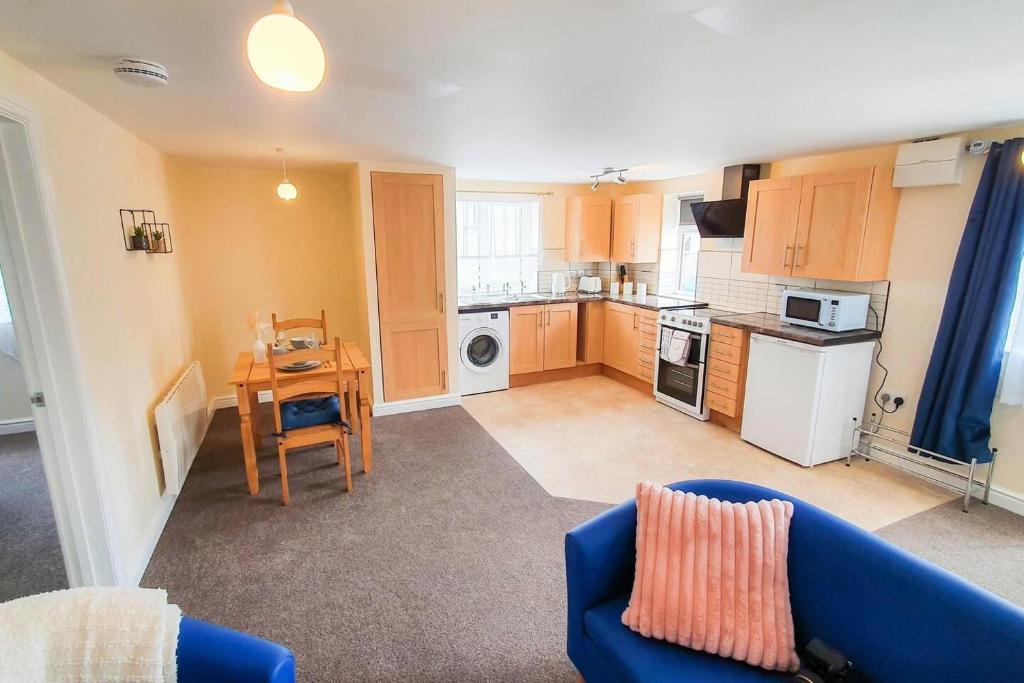 a living room with a blue couch and a kitchen at Captivating 1-Bed Apartment in Stroud in Stroud