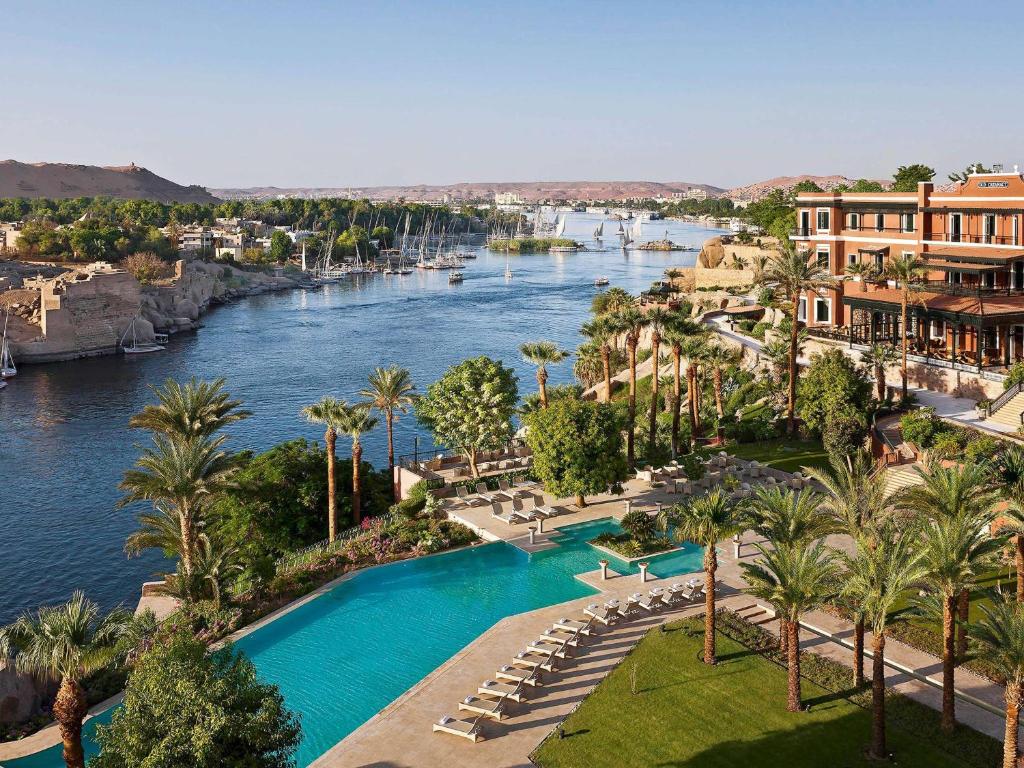an aerial view of a river with palm trees and buildings at Sofitel Legend Old Cataract in Aswan