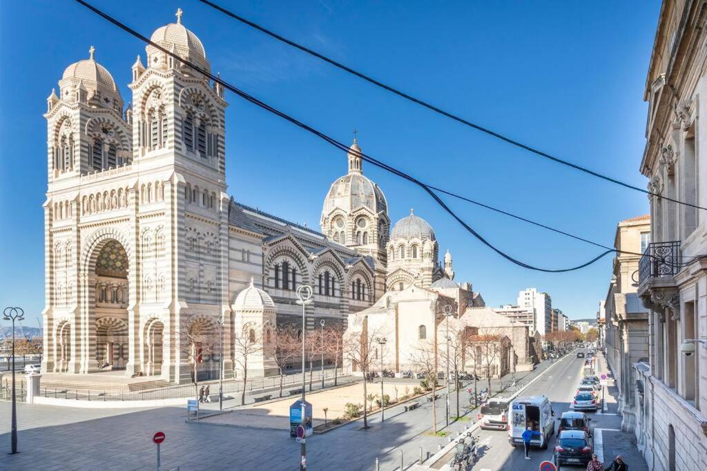 Une grande cathédrale avec des voitures garées devant elle dans l'établissement 7FOUR Appartement avec vu Major, à Marseille