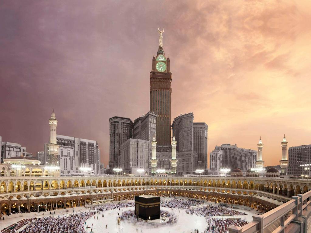 wieża zegarowa w mieście z tłumem ludzi w obiekcie Makkah Clock Royal Tower, A Fairmont Hotel w Mekce