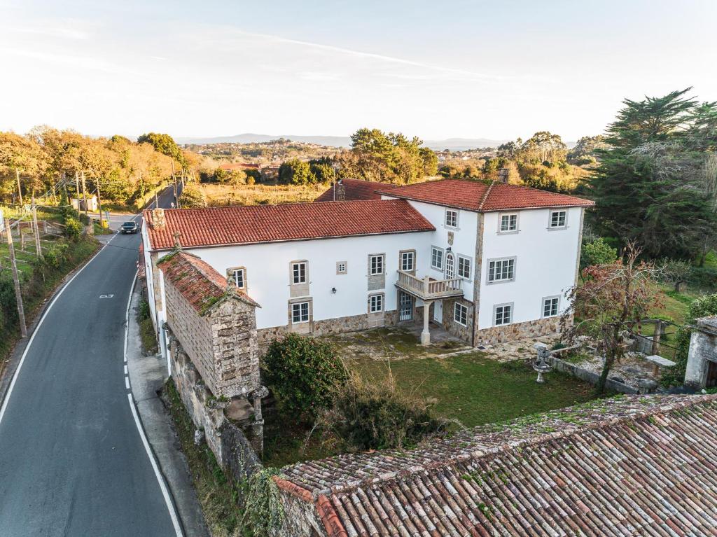 una casa bianca sul ciglio di una strada di Camiño Ancho casa rural a A Pobra do Caramiñal