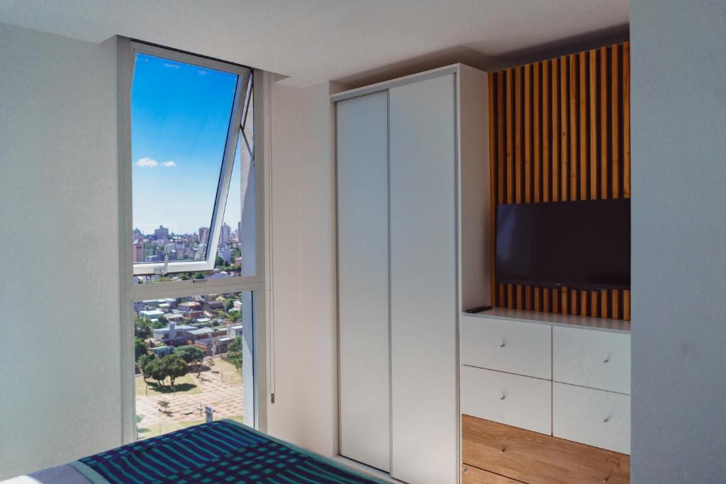 a living room with a tv and a window at Departamento chic Costanera Posadas in Posadas