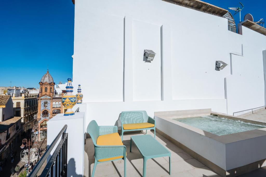 un balcone con sedie e una vasca idromassaggio in un edificio di Ninesuites Cathedral a Siviglia