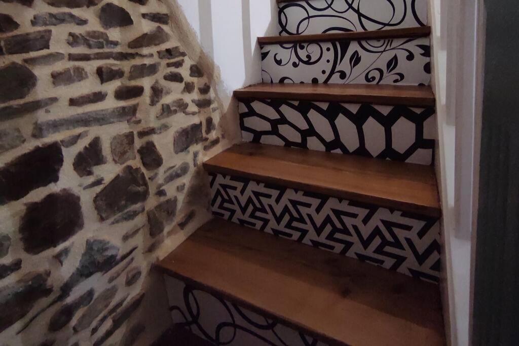 a set of stairs with a stone wall at Maison de ville rénovée au cœur du Cotentin. in Périers