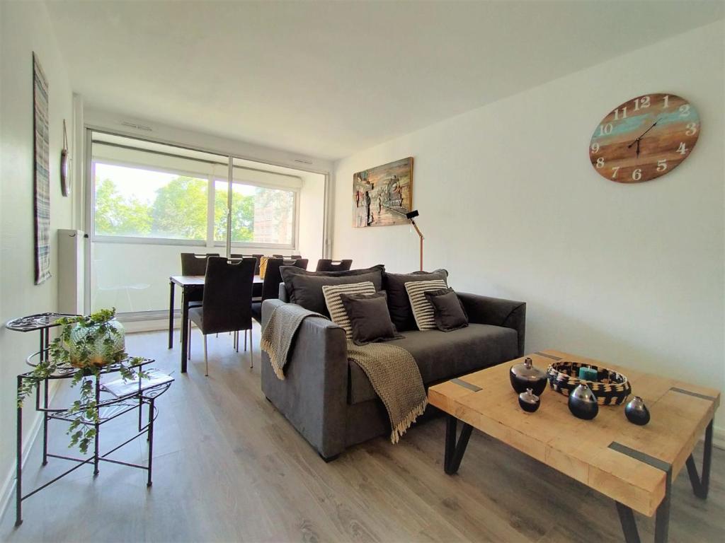 a living room with a couch and a table at Chic and comfortable apart near Paris in Colombes