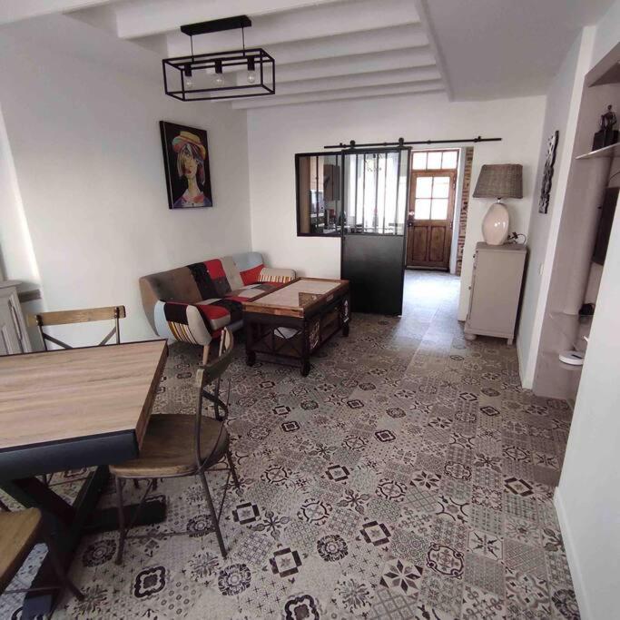 un salon avec un canapé et une table dans l'établissement Maison de ville rénovée au cœur du Cotentin., à Périers