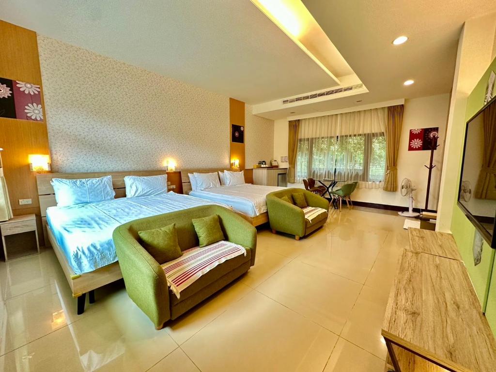 a large bedroom with a bed and a couch and chairs at Li Wu Zuo Cun B&amp;B in Chongde