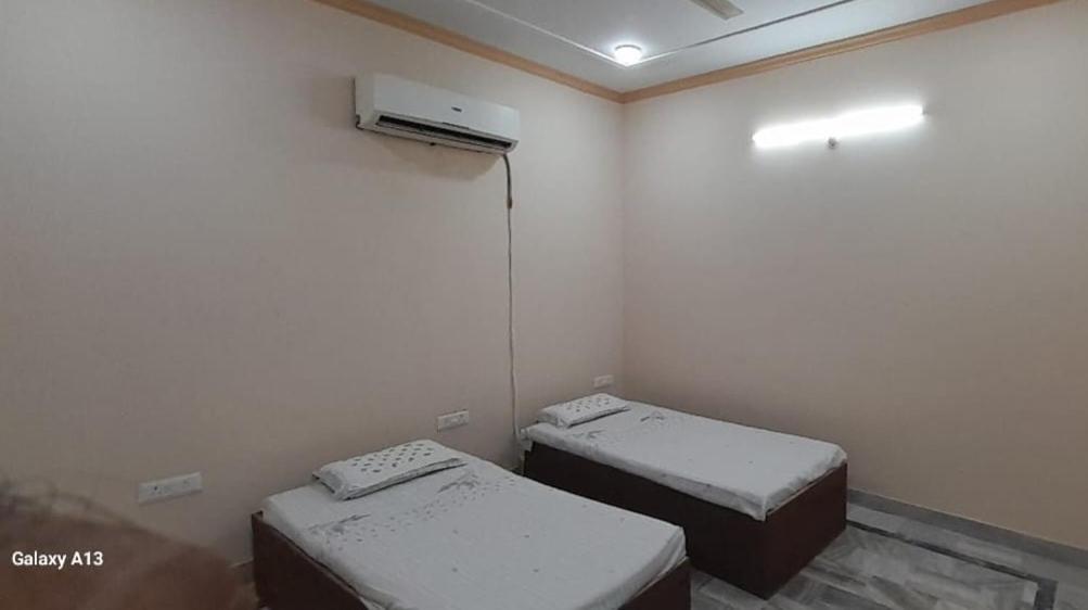 Habitación con 2 camas individuales y calentador. en Prayas homestay, en Agra