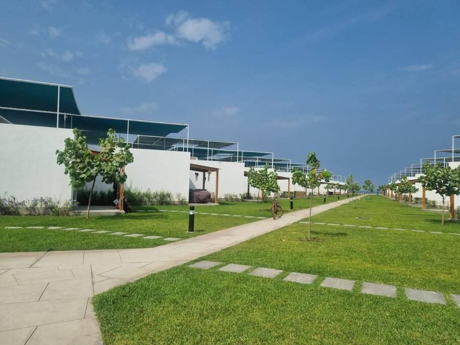 un edificio con un campo de césped junto a un edificio en Casa de Playa en Puerto Viejo, en San Antonio