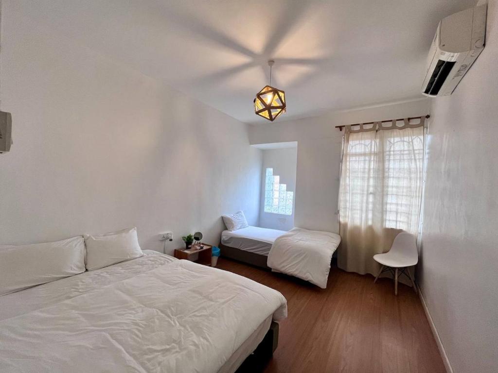 a bedroom with two beds and a window at The Gatherings Place in Melaka