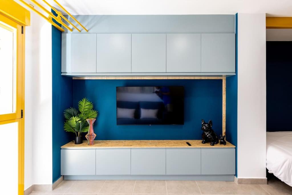 a room with a tv and a blue wall at Estudio moderno y acogedor en Madrid Rio nº5 in Madrid