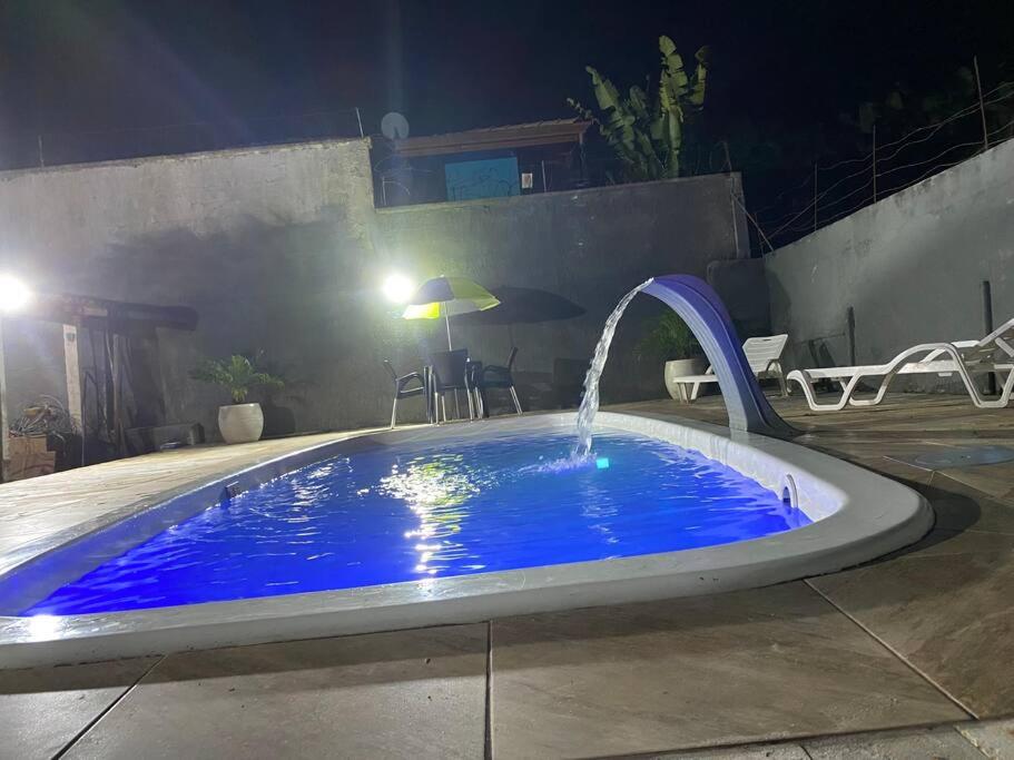 a swimming pool at night with a water fountain at Casa de Praia com piscina in São Sebastião