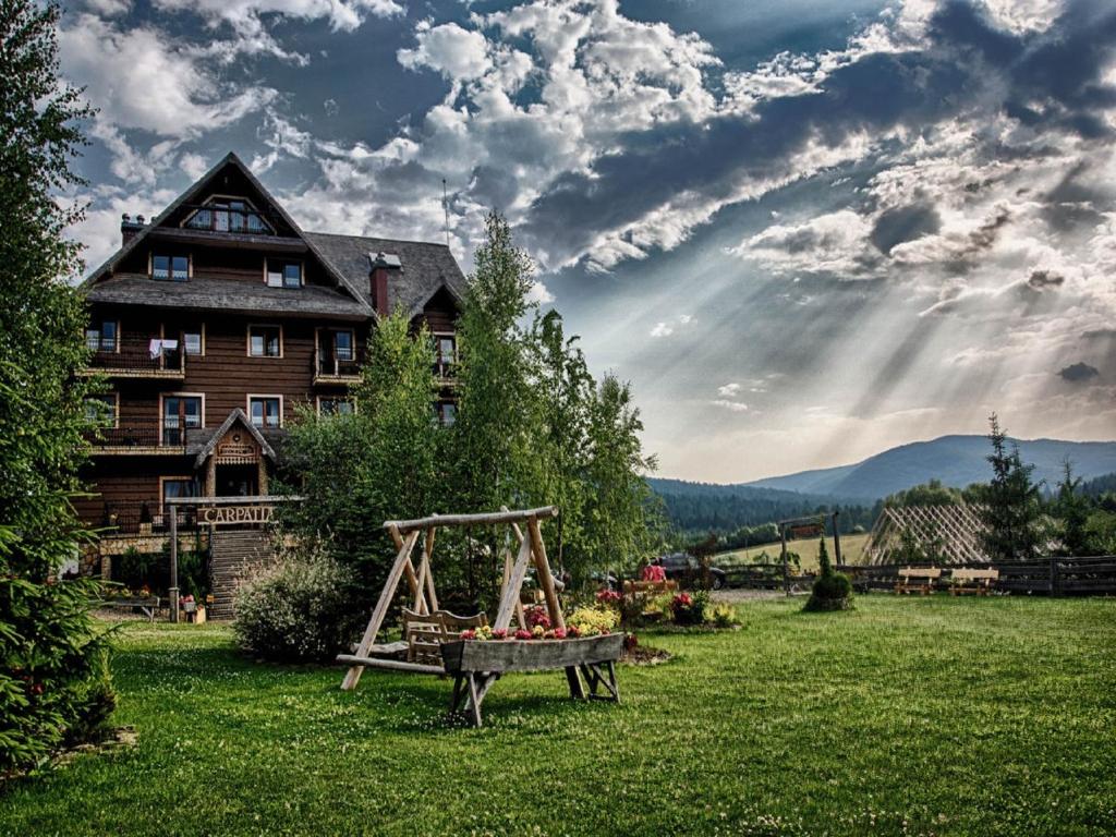 a house with a table of fruit in the yard at Hotel Carpatia Bieszczadzki Gościniec in Wetlina