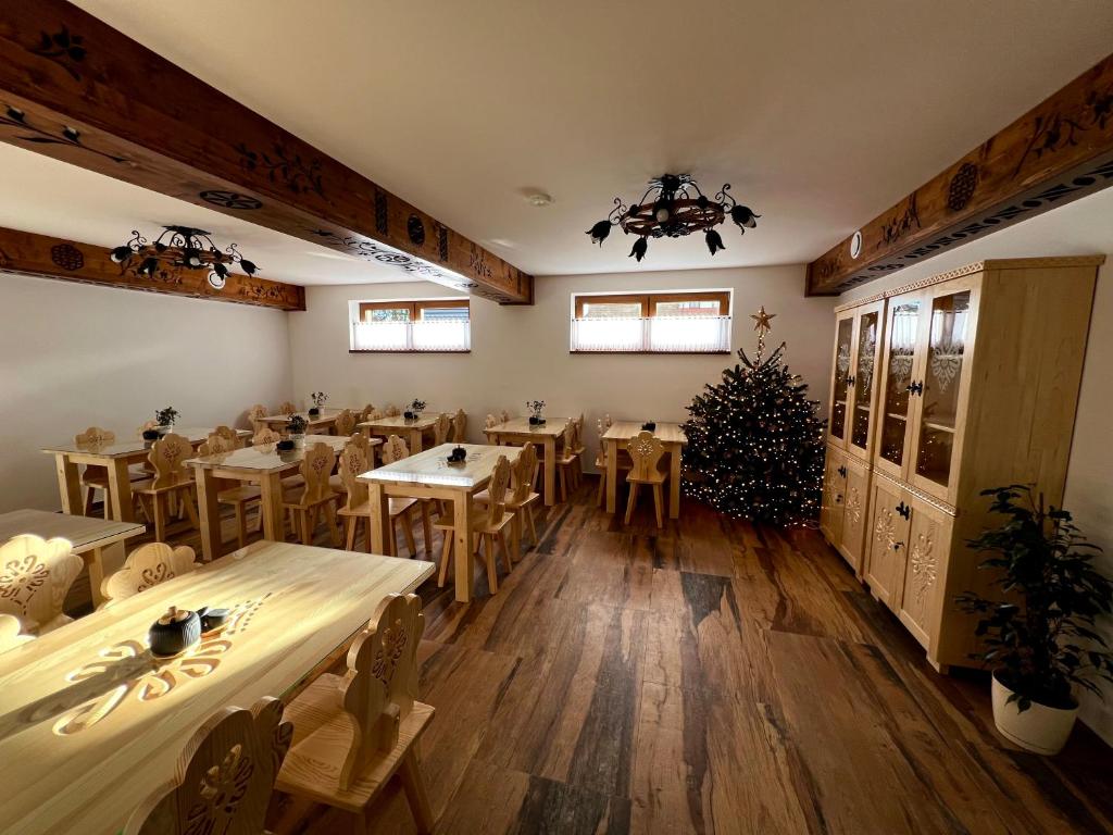 a restaurant with tables and chairs and a christmas tree at Rozeta in Witów