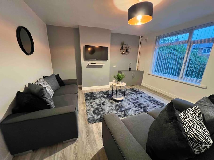 a living room with a couch and a tv at Flaxton-Luxurious Home near NEC, BHX in Birmingham