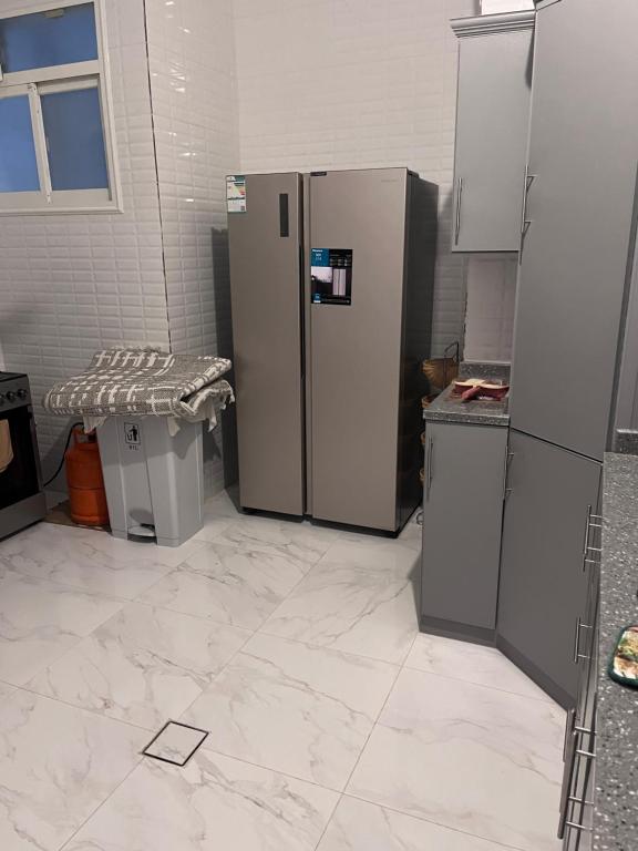 una cucina con frigorifero e 2 bidoni della spazzatura di شقة مميزه a Muhayil