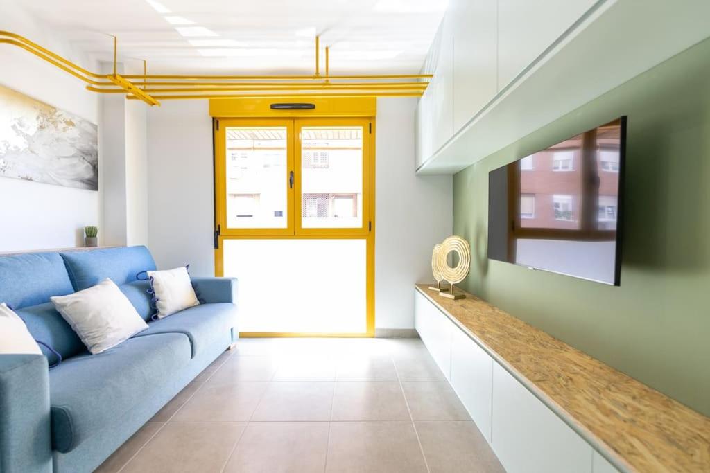 a living room with a blue couch and a tv at Estudio moderno y acogedor en Madrid Rio nº6 in Madrid