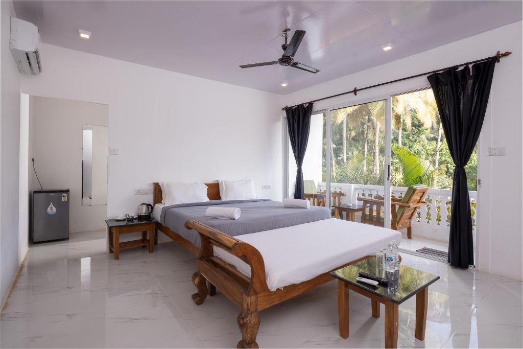 a bedroom with a bed and a large window at Crystall Goa, Onyx Edition in Palolem