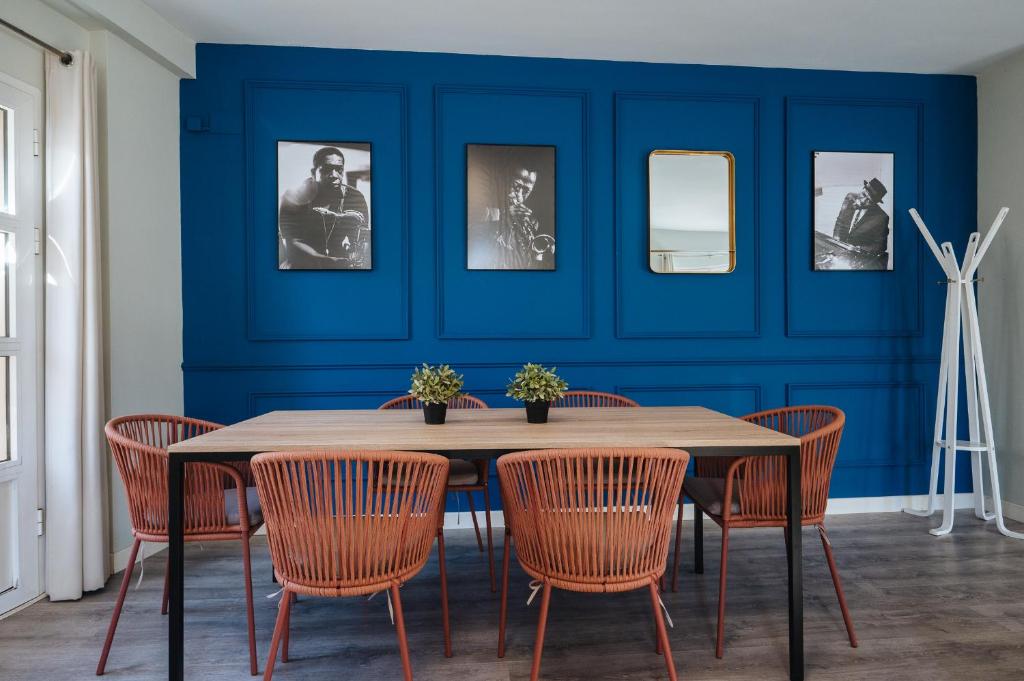 une salle à manger avec un mur bleu, une table et des chaises dans l'établissement The Zentral Suites & Apartments, à Séville