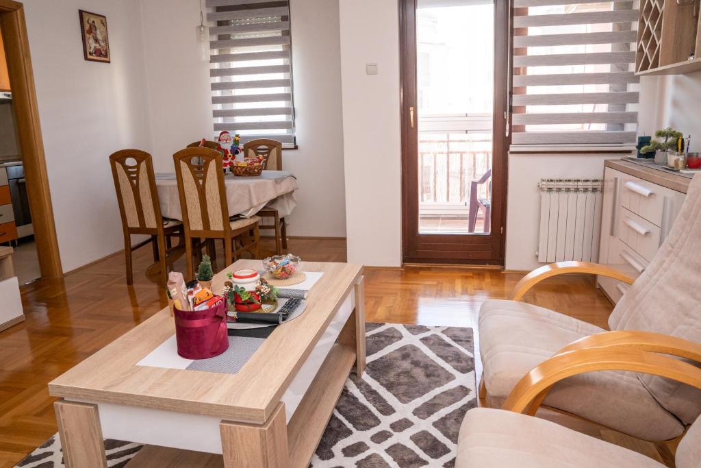ein Wohnzimmer mit einem Tisch und einem Esszimmer in der Unterkunft Apartman Red Rose in Banja Luka