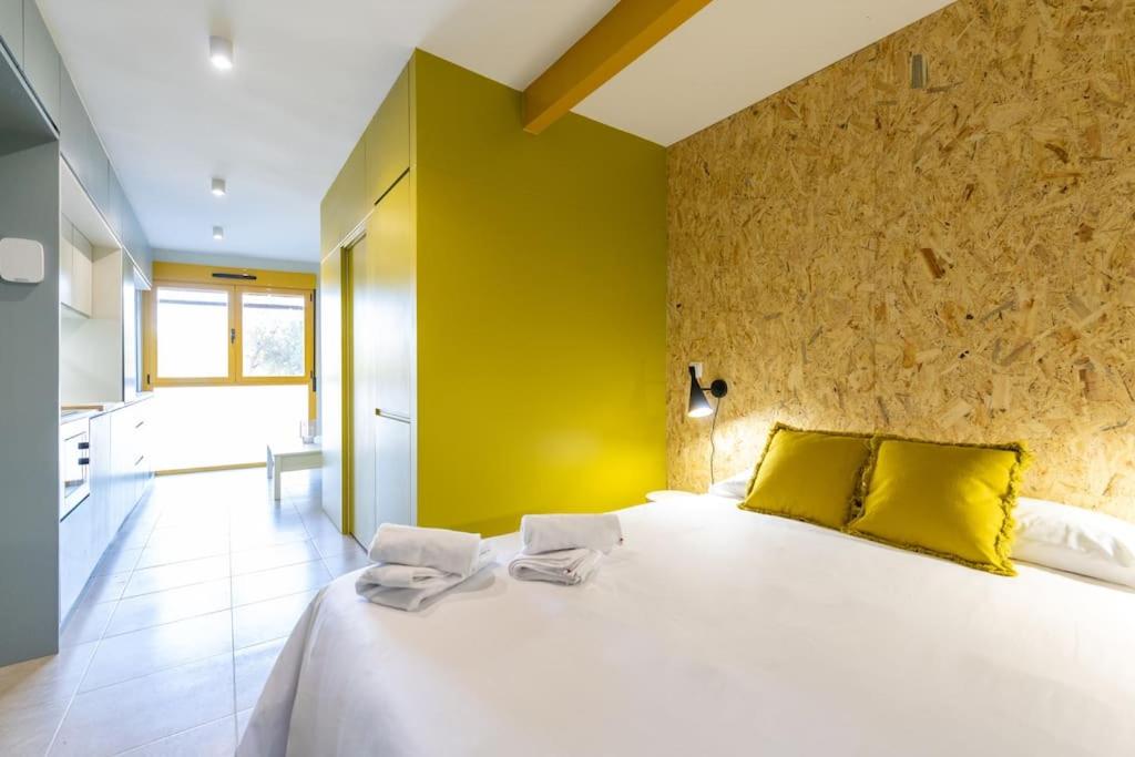 a bedroom with a large white bed with yellow walls at Estudio moderno y acogedor en Madrid Rio nº8 in Madrid