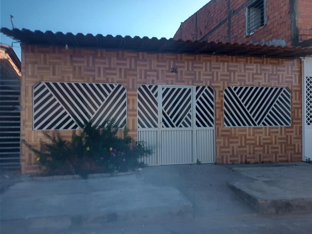 un edificio di mattoni con due cancelli bianchi e una recinzione di Casa da Edileusa a Barreirinhas