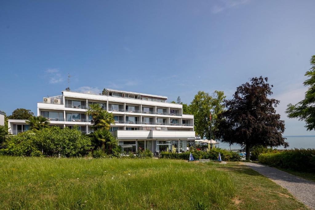 ein großes weißes Gebäude an der Seite eines Feldes in der Unterkunft Park - Hotel Inseli in Romanshorn