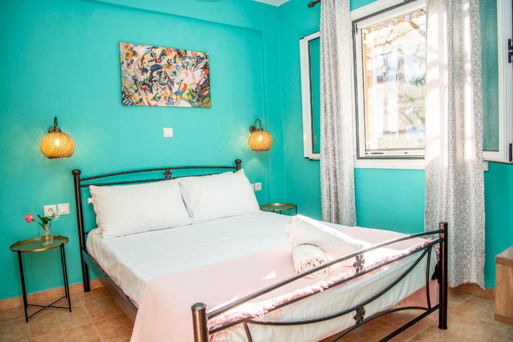 een slaapkamer met blauwe muren en een bed bij The Grapevine Rooms in Póros