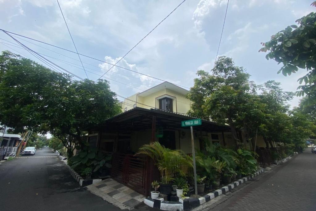 a yellow house on the side of a street at OYO 93444 Damia Homestay Syariah in Surabaya