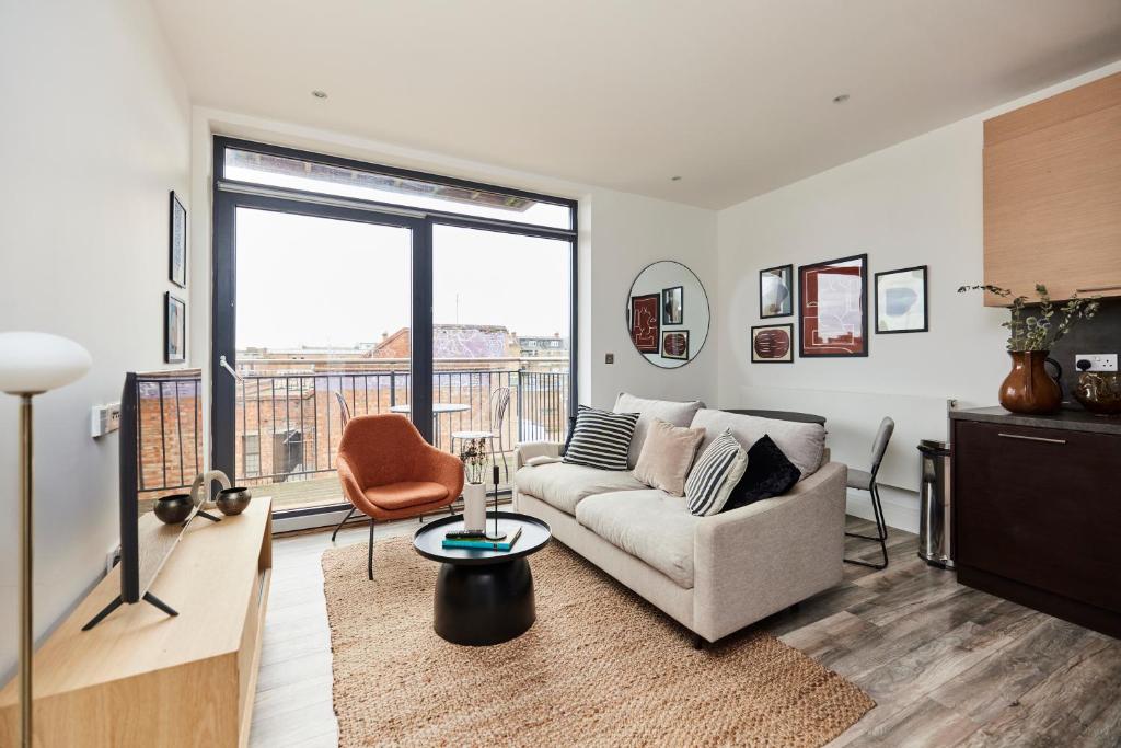 a living room with a couch and a balcony at The Wembley Crib - Lovely 1BDR Flat with Balcony in London