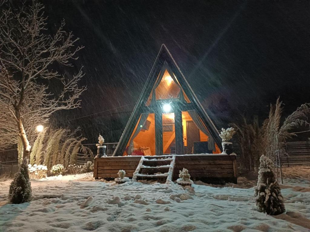 mały domek na śniegu w nocy w obiekcie LabosCottages w mieście Surami