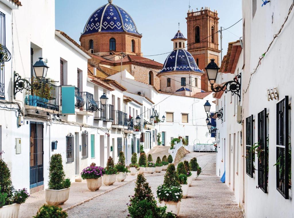 a street in positano with white buildings and blue domes at Apartamento en Altea con vistas al mar in Altea