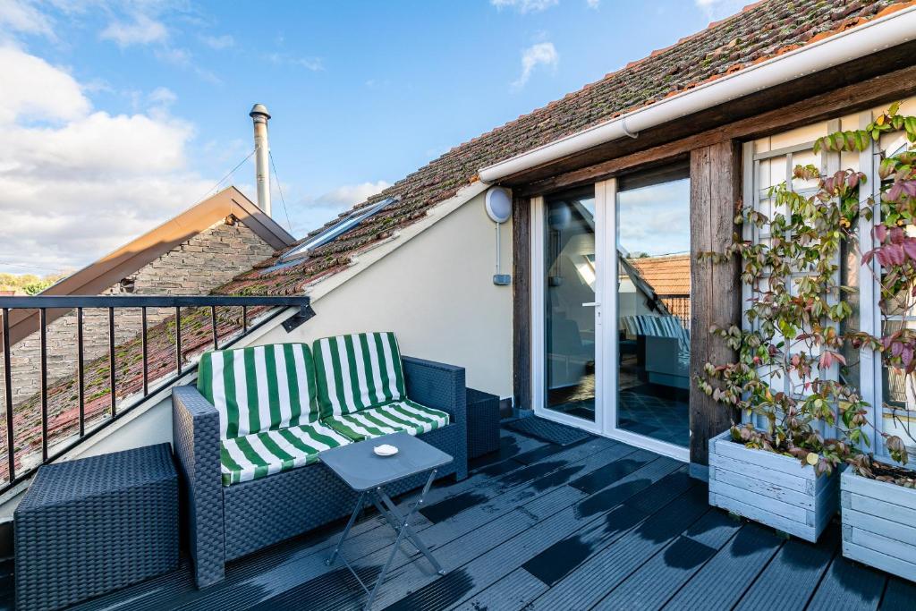 een balkon met 2 stoelen en een tafel bij Le Chêne - Appt au calme pour 5 in Quatzenheim