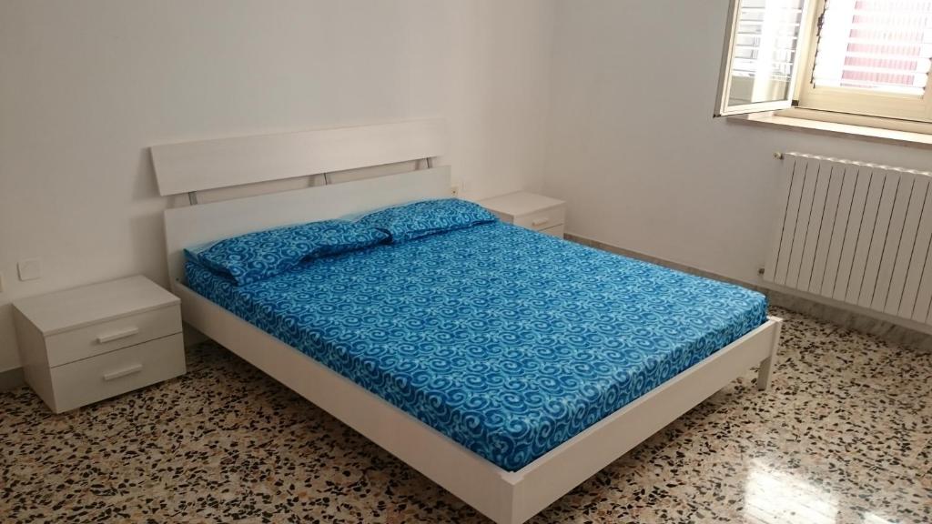 a bedroom with a bed with a blue comforter at STELLA appartamento in Policoro