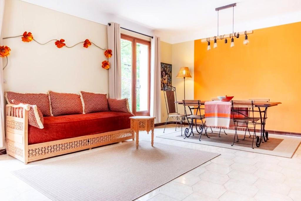 uma sala de estar com um sofá vermelho e uma mesa em Maison de 3 chambres avec jardin clos et wifi a Ceret em Céret